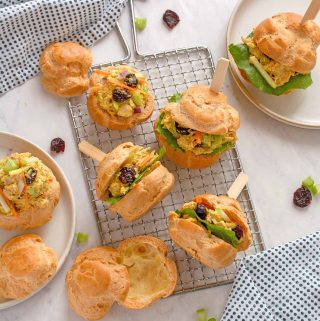 Pâte à choux puffs, cut in half and filled with curried turkey salad, with decorative toothpicks through them to hold in place