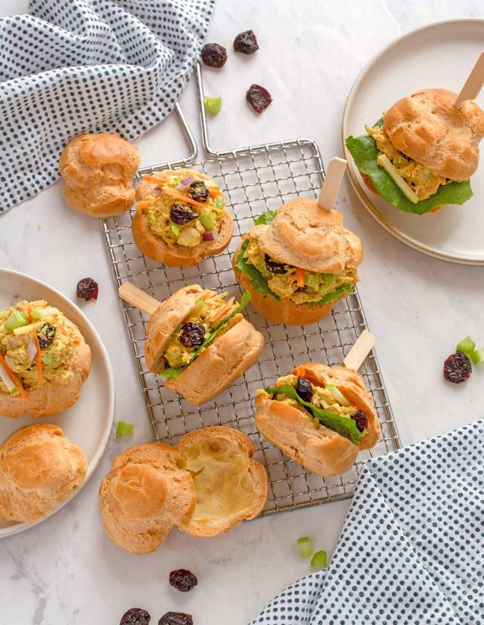 Pâte à choux puffs, cut in half and filled with curried turkey salad, with decorative toothpicks through them to hold in place