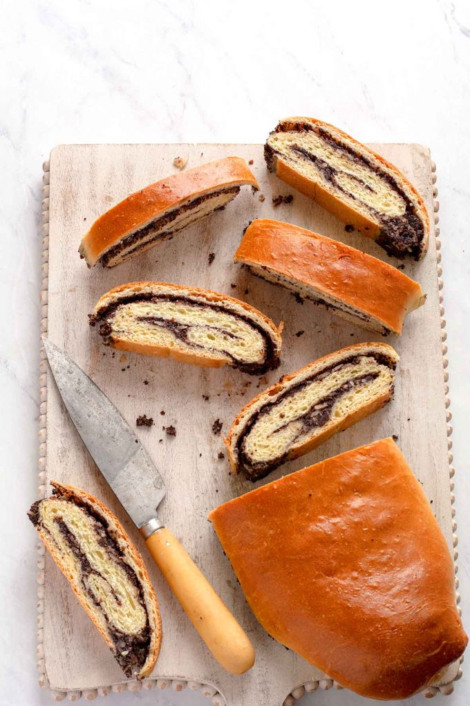 poppy seed roll cut into thin slices on a cutting board