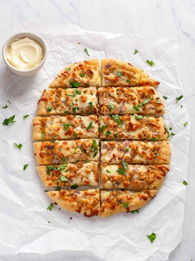 Round pizza topped with ground turkey, red onions and cheese