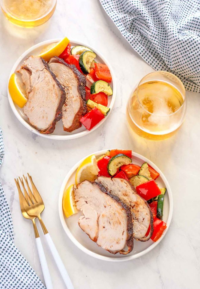 Overhead shot of Sliced turkey breast sitting on roasted veggies. 