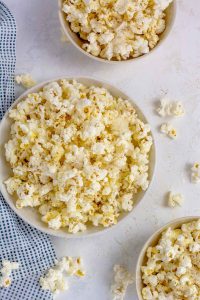 Top down shot of three small bowls of popcorn.