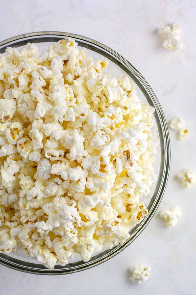 Large glass bowl full of popped popcorn