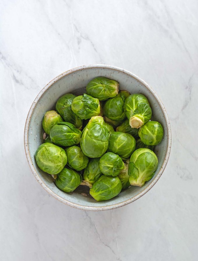 Overhead shot of a bowl of fresh Brussels sprouts.