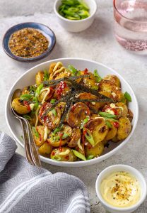 Bowl of roasted Togarashi potatoes. Small bowl of Kewpie mayo in front of bowl of potatoes.