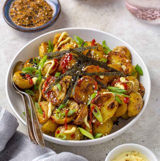 Bowl of roasted Togarashi potatoes. Small bowl of Kewpie mayo in front of bowl of potatoes.